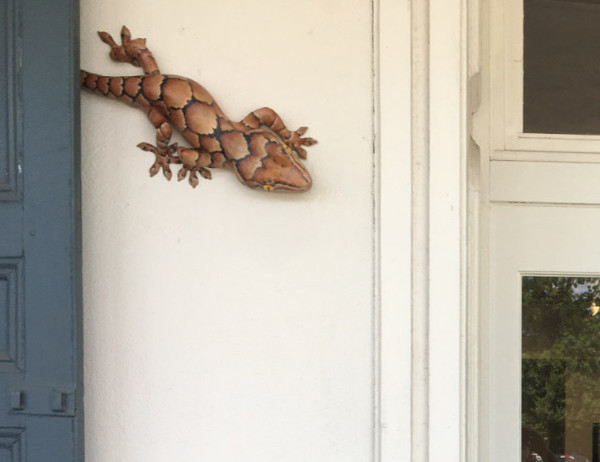 gecko sculpture mounted near the front door of an art center
